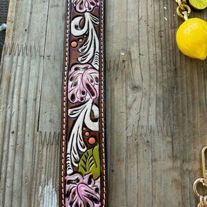 Cute brown wrist cuff with white and pink design .